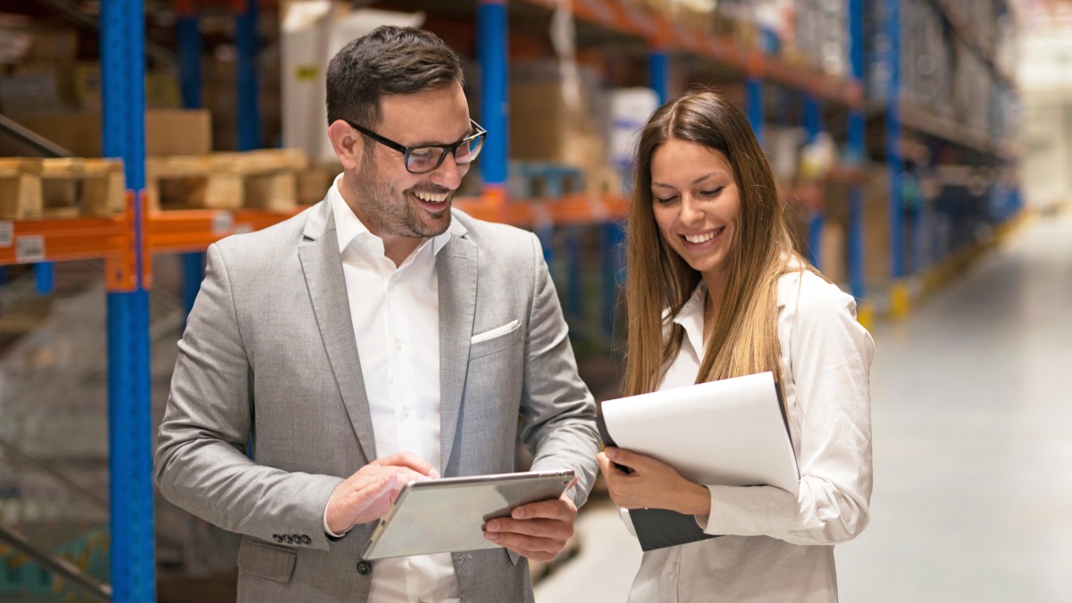 OGeprüfte Fachwirte für Logistiksysteme (Mann und Frau) in großer Lagerhalle