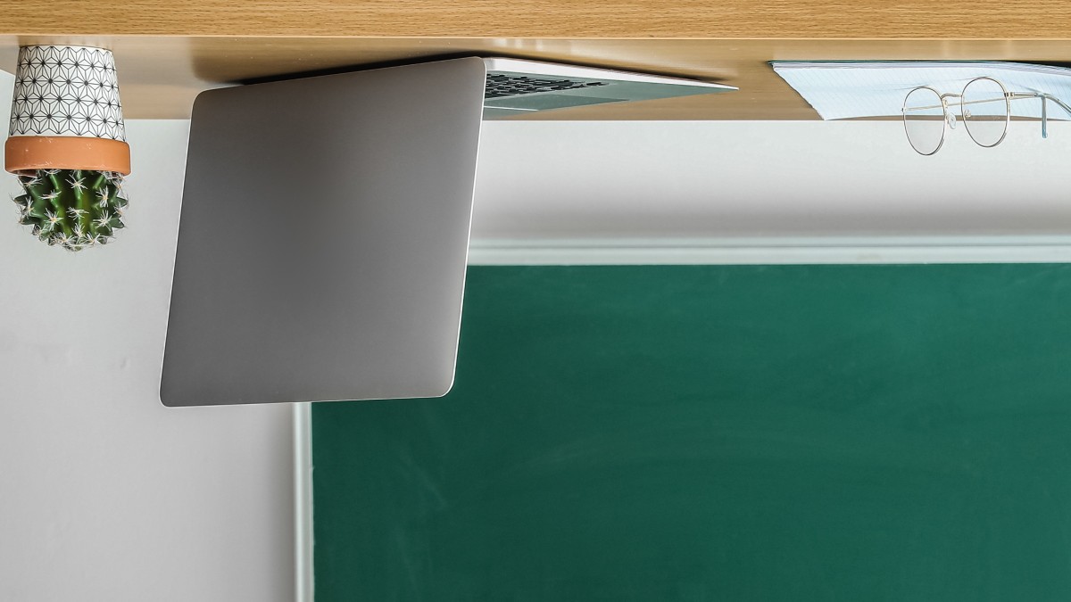 Virtual Flipped Classroom Konzept Laptop auf dem Kopf: Bild verdeutlicht das didaktisches Lern-Konzept Flipped Classroom bei manQ