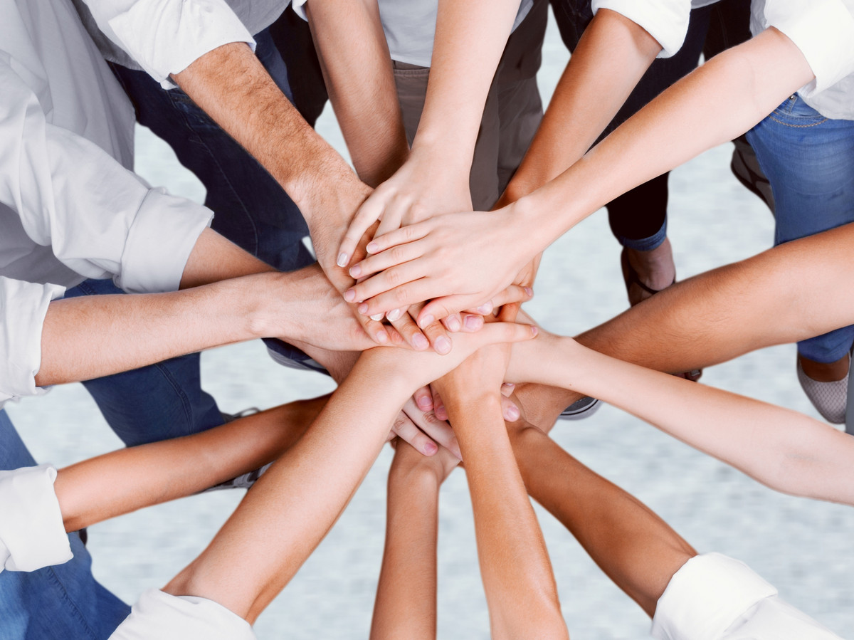 Werde Teil der manQ-Familie Hände aufeinandergelegt: Teamwork bei manQ