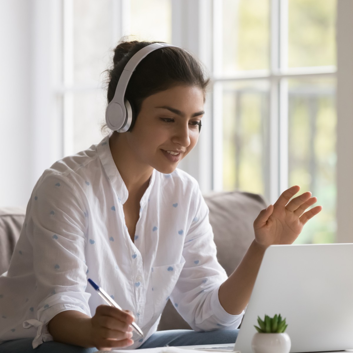 Live-Online-Lehrgänge bei manQ Frau mit Headset nimmt online an einem virtuellen Unterricht von manQ teil