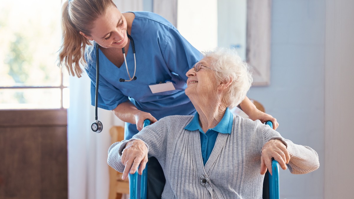 Ausbildungsberufe im Gesundheits- und Sozialwesen Eine Pflegefachfrau schiebt eine ältere Frau im Rollstuhl