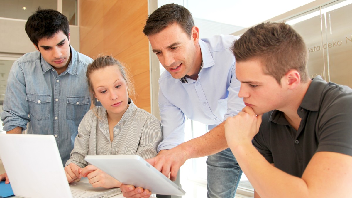 Ausbilder unterweist Auszubildende in Firma