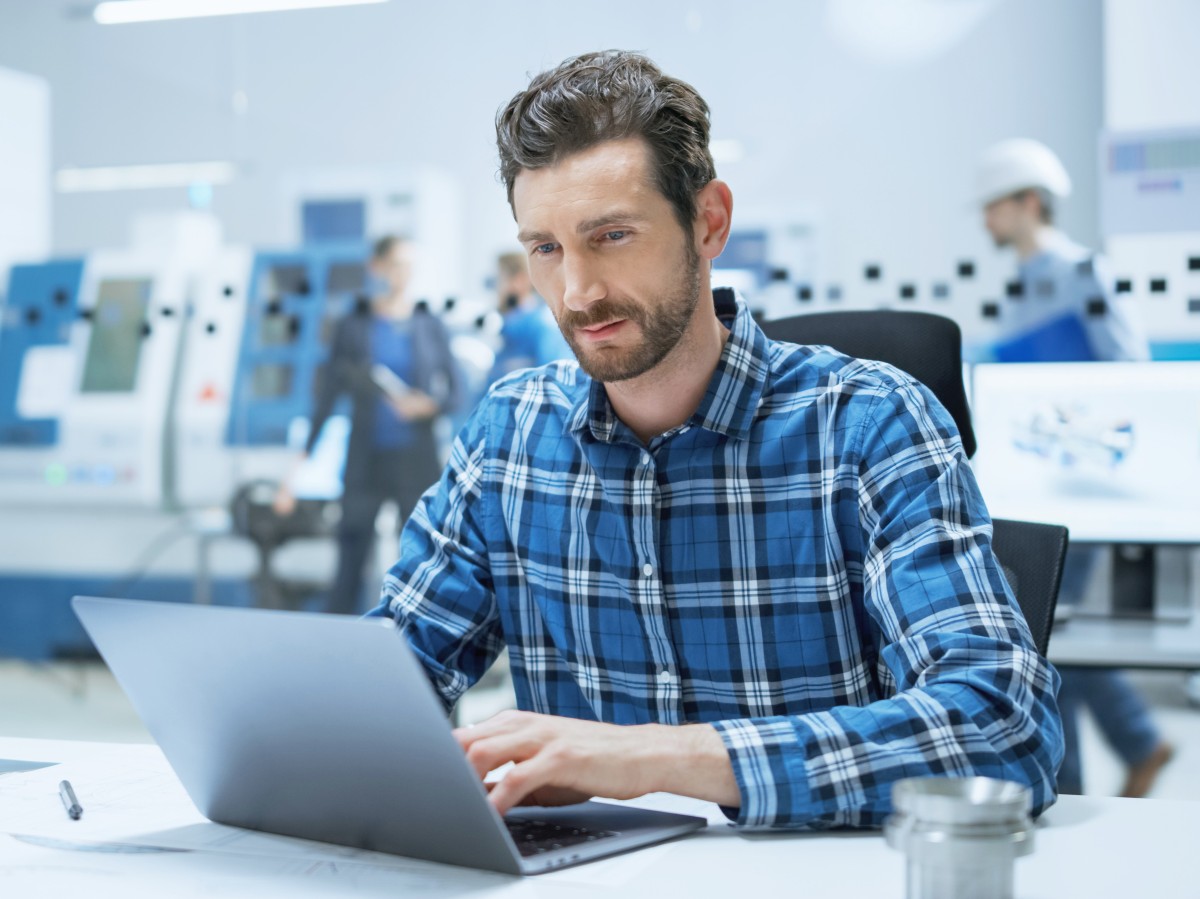 Technischer Betriebswirt sitzt am Laptop