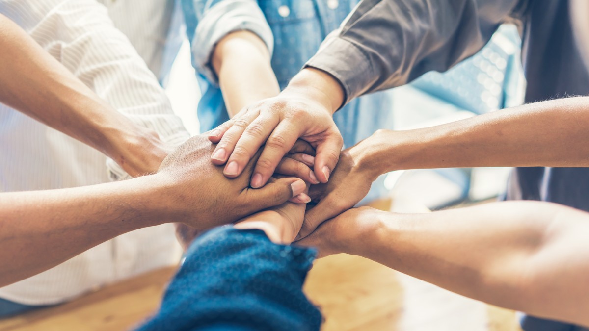 Hände aufeinandergelegt: Teamwork bei manQ