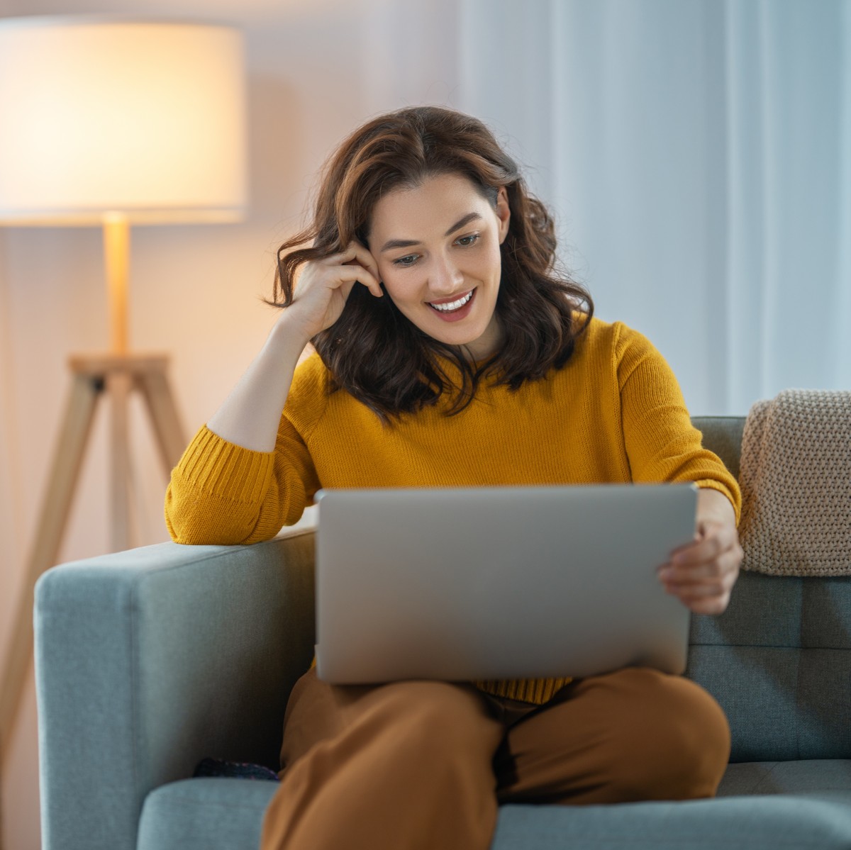 Zum Online-Infoabend anmelden Frau sitzt vor dem Laptop, um Fragen zum kostenfreien Online-Infoabend zu klären